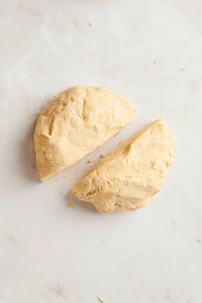 Pie dough divided into two equal portions, ready to be shaped into discs for chilling.