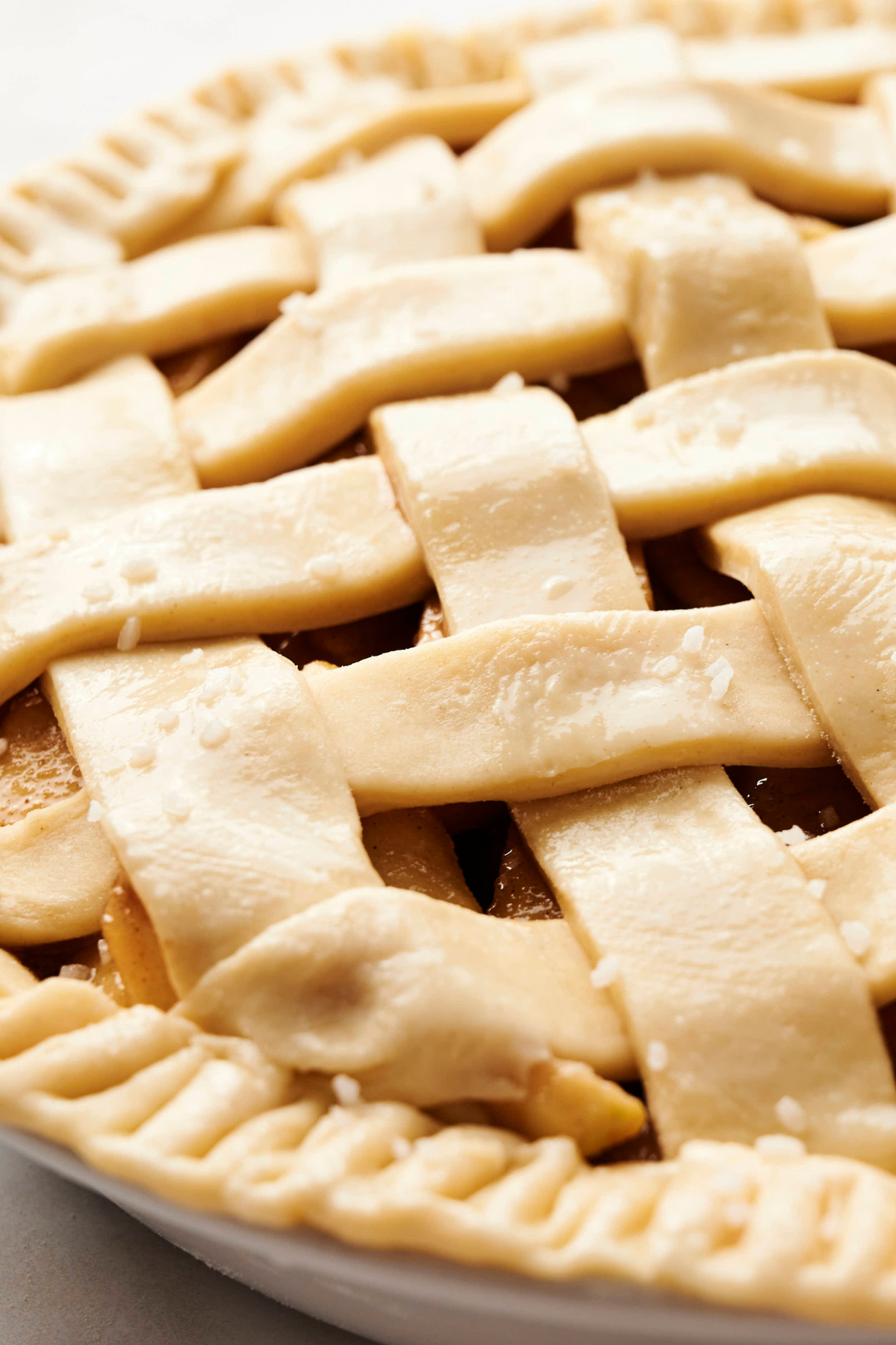 Homemade All Butter Pie Crust Recipe Close-up of a golden, flaky lattice pie crust made with homemade all-butter dough, sprinkled lightly with sugar crystals before baking.