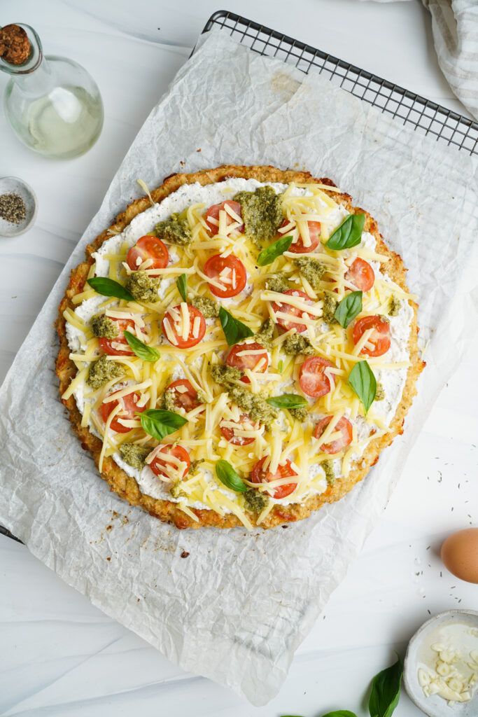 Pizza au chou-fleur garnie de tomates cerises, mozzarella et basilic frais | cookingwithcassandra.com