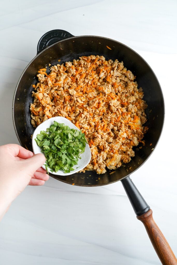 Ajout de Feuilles de Coriandre Hachées au Poulet Haché | cookingwithcassandra.com