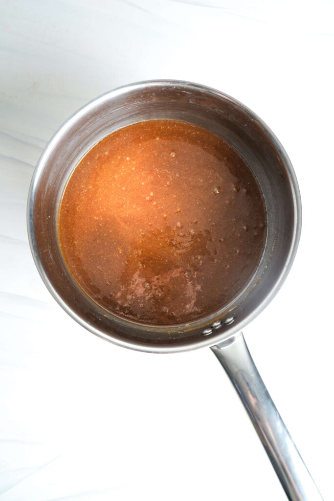 Glaçage maison au sucre brun avec miel, Dijon, ail et zeste d'orange dans une casserole