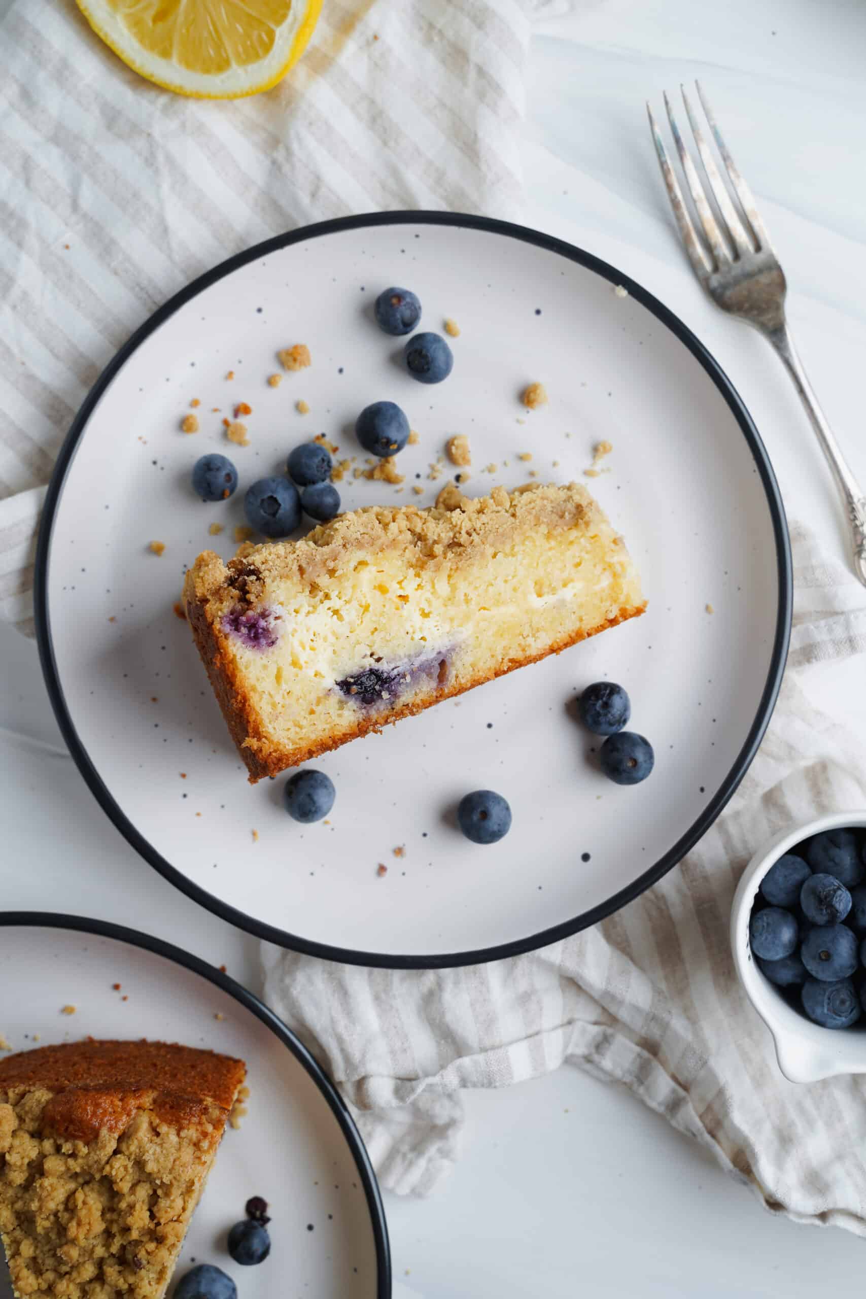 Tranche de gâteau au citron et myrtilles avec des myrtilles fraîches sur le côté | cookingwithcassandra.com